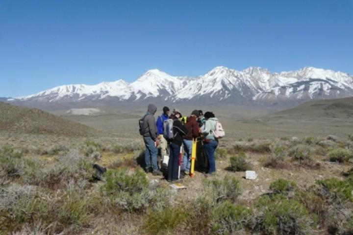 一群学生站在以山脉为背景的田野上