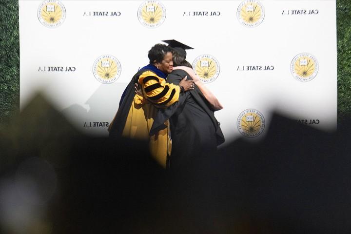 在2024年毕业典礼上，总统埃恩斯给了一位毕业生一个拥抱.