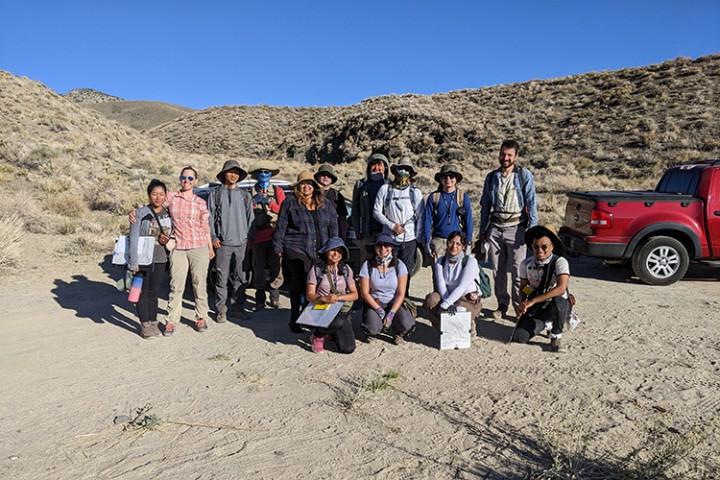 一群14名学生站在沙漠里.