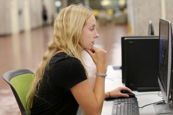 Image of female student in University Library using a computer station. 